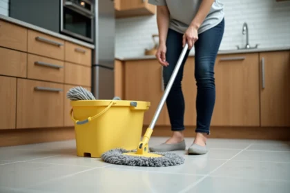 Femme utilisant une serpillière essoreuse avec seau à pédale sur carrelage de cuisine pour désinfecter le sol